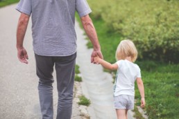 father and daughter walking and holding hands