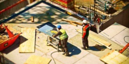 two contractors using tools and working on constructing a building