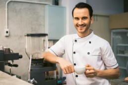 male barista wearing a white outfit
