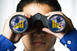 man looking at trends through binoculars