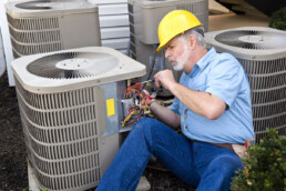 hvac contractor working on central air unit