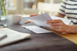person reviewing paper documents at table
