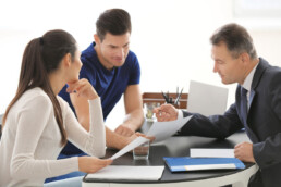 insurance agent and clients reviewing a document in office together